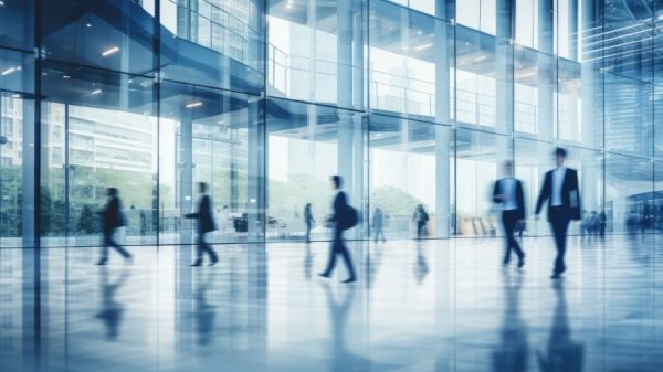 Long exposure shot of crowd of business people walking in bright office fast moving with blurry